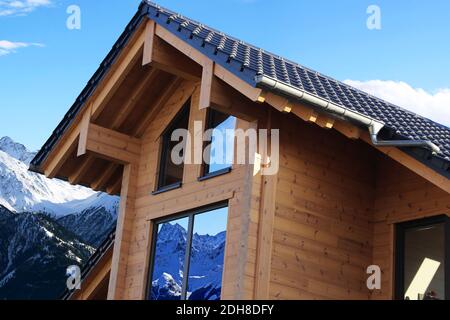 Fotomontage: Modernes neues Holzhaus in den Bergen (Winter) Stockfoto