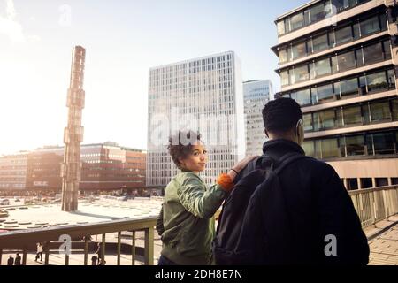 Portrait von Teenager-Mädchen zu Fuß mit Freund auf Brücke in Stadt Stockfoto