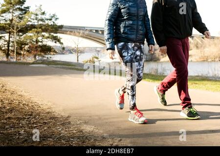 Niedriger Abschnitt von Mann und Frau in Sportbekleidung zu Fuß auf Straße Stockfoto