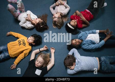 Direkt über dem Schuss der Schulkinder, die auf dem Boden liegen Schulungsraum Stockfoto