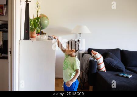 Seitenansicht des Jungen Reinigungsschrank mit Serviette im Leben Zimmer Stockfoto