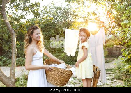 Mutter und Tochter hängen Wäsche im Hinterhof Stockfoto
