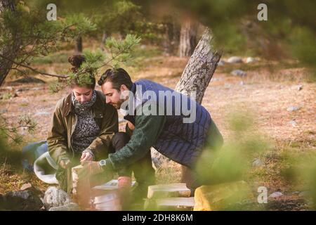 Paar hält Brennholz auf dem Campingplatz Stockfoto