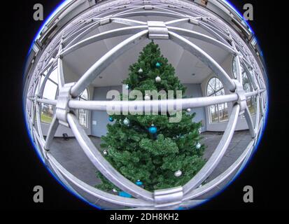 Boltenhagen, Deutschland. Dezember 2020. In der Konzertmuschel an der Strandpromenade steht ein geschmückter Weihnachtsbaum, der mit einem Metallgitter verschlossen ist. (Aufgenommen mit extrem Weitwinkelobjektiv) aufgrund der teilweisen Coronasperre sind Hotels, Restaurants und touristische Einrichtungen an der Ostseeküste in Mecklenburg-Vorpommern geschlossen. Quelle: Jens Büttner/dpa-Zentralbild/dpa/Alamy Live News Stockfoto