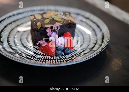 Dunkle Schokolade hausgemachtes Keto vegan mehllos Brownie Dekoration mit Blume. Ketogene Low Carb und glutenfreie Ernährung Stockfoto