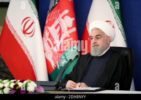 Teheran, Iran. Dezember 2020. Ein Handout-Bild der offiziellen Website des iranischen Präsidenten am 10. Dezember 2020 zeigt Präsident Hassan Rohani zu Beginn einer Videokonferenz mit seinem afghanischen Amtskollegen zur Eröffnung der ersten Eisenbahnverbindung zwischen Kaf im Iran und Herat in Afghanistan, Im Präsidentenpalast in Teheran. Quelle: Iranischer Vorsitz/ZUMA Wire/Alamy Live News Stockfoto