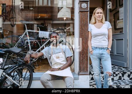 Portrait von selbstbewussten Besitzern gegen Fahrradladen Stockfoto