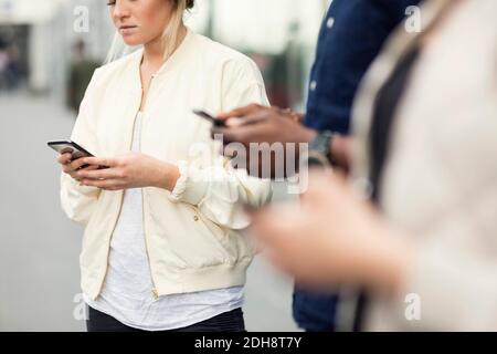 Mittelteil von jungen Freunden mit Smartphones in der Stadt Stockfoto