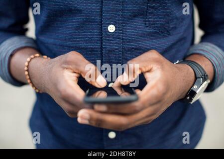Mittelteil des Mannes mit Handy Stockfoto