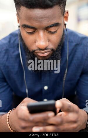 Mann, der Musik vom Handy in der Stadt hört Stockfoto