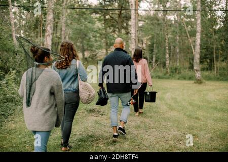 Rückansicht von Töchtern mit Familie, die während des Spazierens im Wald unterwegs sind Urlaub Stockfoto