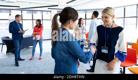 Geschäftsfrauen, die sich in einem Büro die Hände schütteln Stockfoto