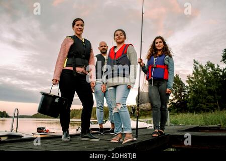 Low-Angle-Porträt der Familie auf Pier während des Sonnenuntergangs stehen Stockfoto