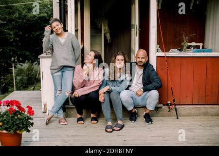 Lächelnde Familie verbringt Zeit zusammen, während im Hof genießen während Sommer Stockfoto