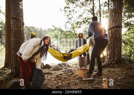 Männliche und weibliche Freunde genießen im Wald während des Urlaubs Stockfoto