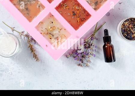 Handgemachte Seife, der Prozess der Herstellung. Glyzerin mit Kräutern, gegossen in eine spezielle Form zum Trocknen, Overhead-Schuss Stockfoto