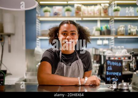 Porträt einer lächelnden Verkäuferin an der Kasse im Supermarkt Stockfoto