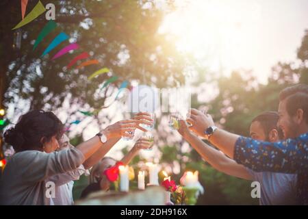 Multi-ethnische Freunde toasten Getränke auf Gartenparty Stockfoto