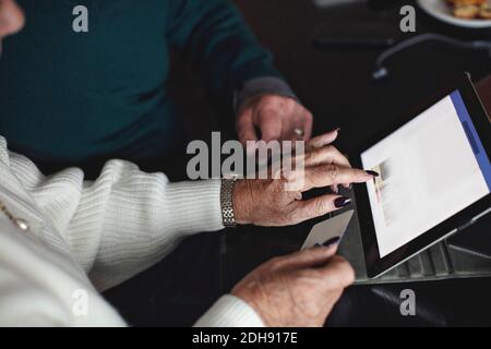 Ältere Paare einkaufen online über digitale Tablet zu Hause Stockfoto