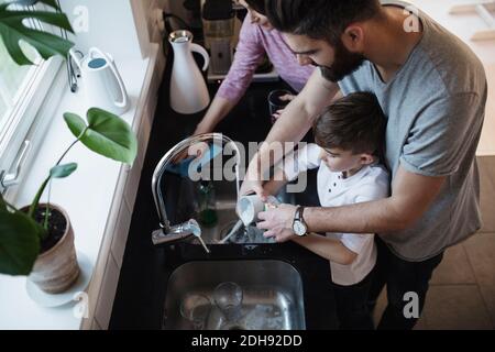 Aus der Sicht von Vater und Sohn beim Abwaschen Frau Reinigungstisch in der Küche Stockfoto