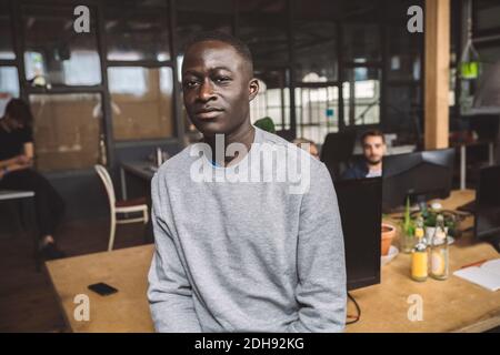 Portrait von zuversichtlich Geschäftsmann am Arbeitsplatz Stockfoto