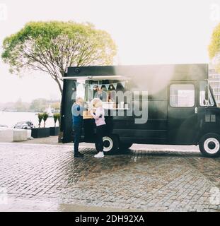 Besitzer im Gespräch mit älteren Kunden, während in kommerziellen Land Fahrzeug Stockfoto