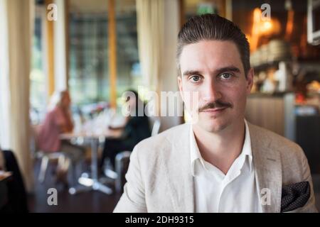 Porträt von zuversichtlich Geschäftsmann sitzen im restaurant Stockfoto