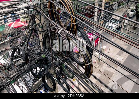 Chaotische elektrische Kabel in Bangkok - Beispiel für nicht abgedeckte optische Glasfasertechnologie im Freien in südostasiatischen Städten Stockfoto