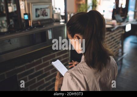 High-Angle-Ansicht der weiblichen Köchin mit Smartphone in Restaurant Stockfoto