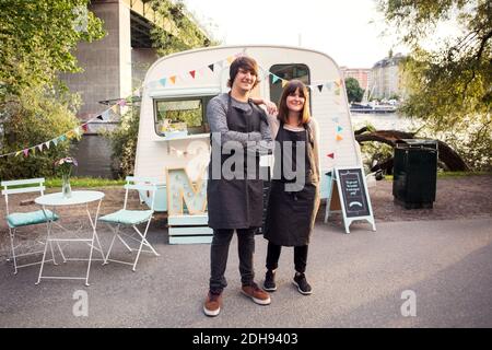 In voller Länge Porträt von selbstbewussten Besitzer stehen auf der Straße gegen Foodtruck Stockfoto