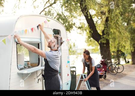 Besitzer arbeiten außerhalb Lebensmittel-LKW auf der Straße Stockfoto