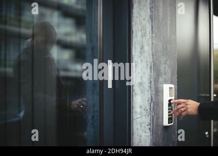 Zugeschnittenes Bild der Hand eines Geschäftsmannes, der den Sicherheitscode zum Öffnen eingibt Bürotür Stockfoto