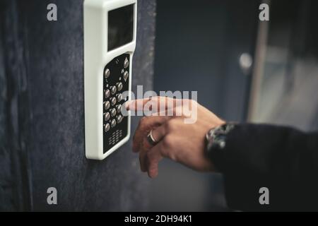 Zugeschnittenes Bild der Hand des Geschäftsmannes, der den Schlüsselcode eingibt Stockfoto