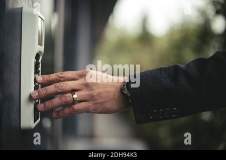 Zugeschnittenes Bild der Hand eines Geschäftsmannes, der den Sicherheitscode eingibt Stockfoto