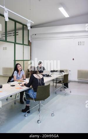 Zwei Frauen diskutieren am Schreibtisch im Kreativbüro Stockfoto