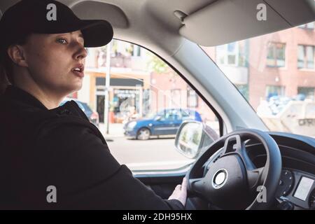 Seitenansicht des Fahrers, der den Lkw in der Stadt fährt Stockfoto