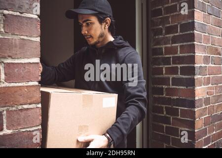 Lieferer mit Paket in der Tür stehen Stockfoto