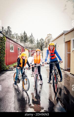 Weibliche und männliche Geschwister fahren Fahrrad am Morgen Stockfoto