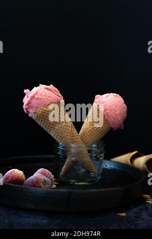 Erdbeer-Eiszapfen in Glas auf dunklem Hintergrund. Moody Eis. Nachtisch. Stockfoto