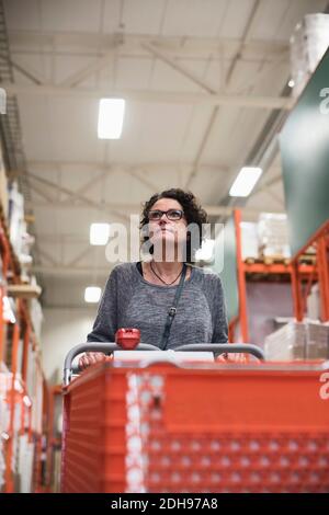 Der Kunde schaut weg, während er den Warenkorb im Baumarkt hält Stockfoto