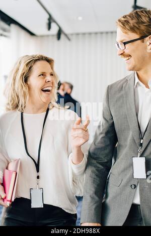 Glückliche Frau beim Gehen mit Kollegen im Büro Stockfoto