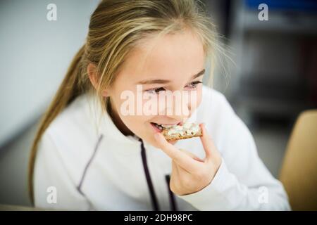 High-Angle-Ansicht des Mädchens mit Essen während der Mittagspause In der Cafeteria Stockfoto