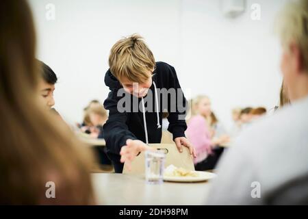 Junge Abholung Glas Trinkwasser in der Schule Cafeteria Stockfoto