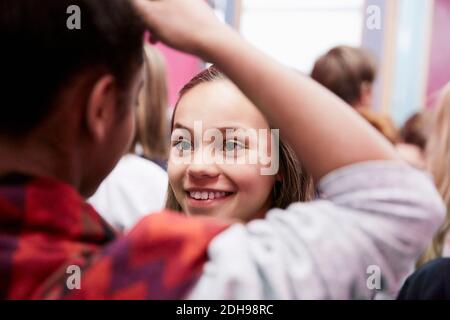 Lächelndes Mädchen, das eine Freundin in der Mittelschule anschaut Stockfoto