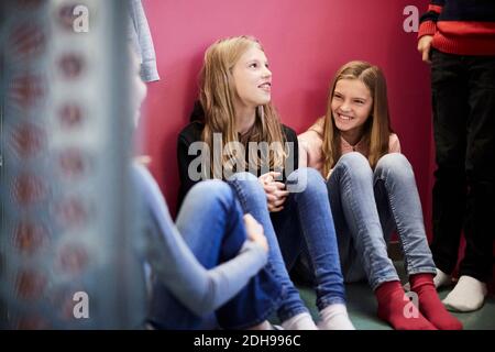Lächelnde Mädchen mit Freunden im Schulgebäude Stockfoto