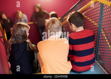 Rückansicht der Junior-Studenten auf der Treppe sitzen Stockfoto