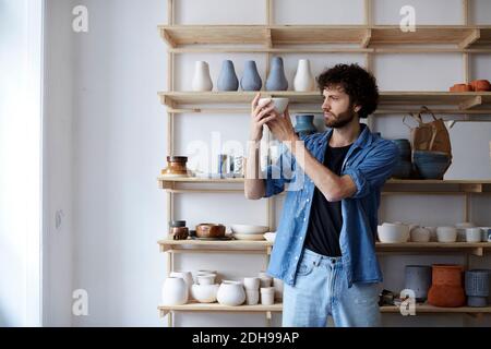 Mittelerwachsener Mann, der im Kunststudio Steingut macht Stockfoto