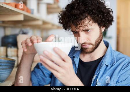 Mann untersucht Schüssel in Keramik-Klasse Stockfoto