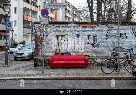 Verlassene, gedumpte, ausgediente, ungewollte rote Ledersofas neben Graffiti-bedeckten Wänden in der Kleinen Rosenthaler Straße, Mitte, Berlin Stockfoto