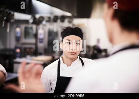 Weibliche Chef Schüler hören Lehrer in Kochschule Stockfoto